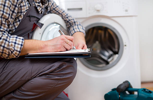 repairman is repairing a washing machine. entering malfunction